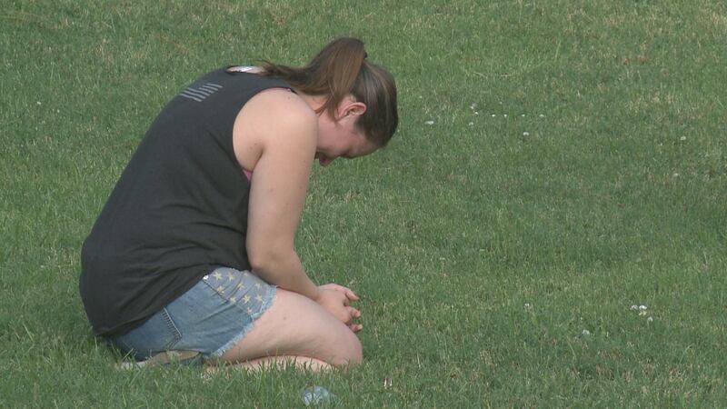 A woman kneels at the silent prayer event in Ardmore Tuesday evening.