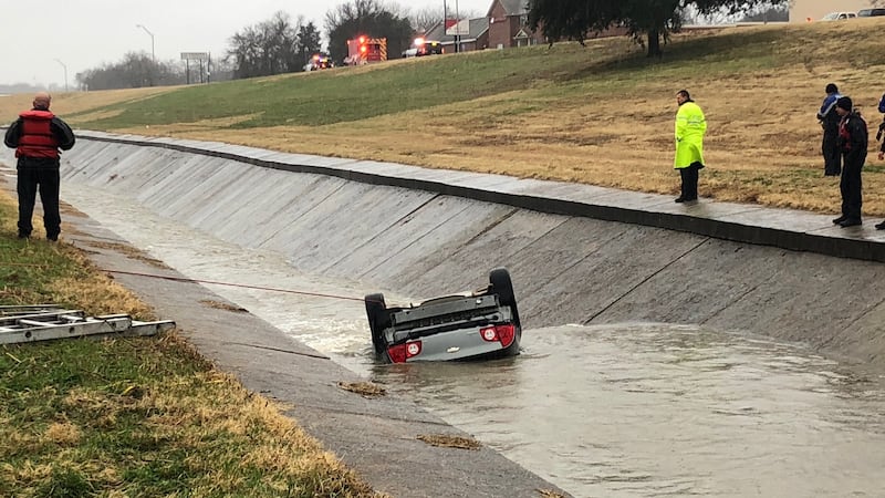 Crews are working to remove a car that flipped into a ditch Thursday afternoon in Sherman.